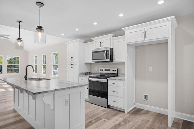 kitchen featuring a kitchen island with sink, sink, white cabinets, decorative light fixtures, and stainless steel appliances