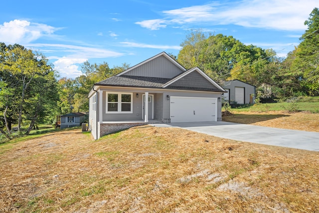 view of front of house with a garage, a front yard, and a storage unit