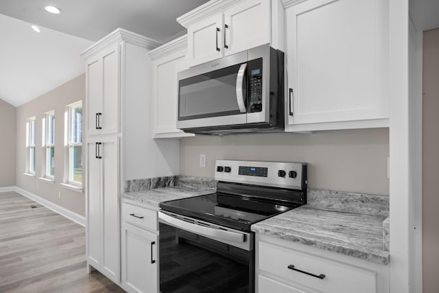 kitchen featuring light stone countertops, white cabinetry, and appliances with stainless steel finishes