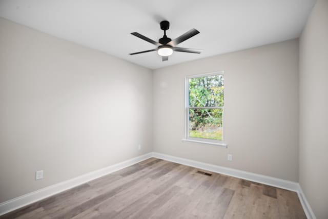 empty room with ceiling fan and light hardwood / wood-style flooring