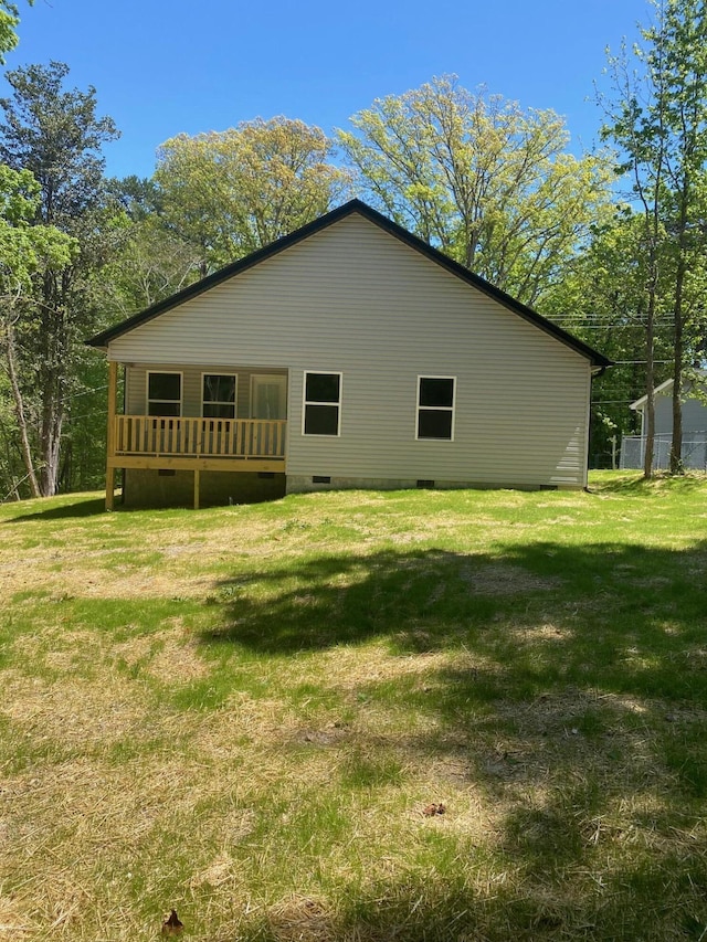 view of side of property featuring crawl space, a yard, and a wooden deck