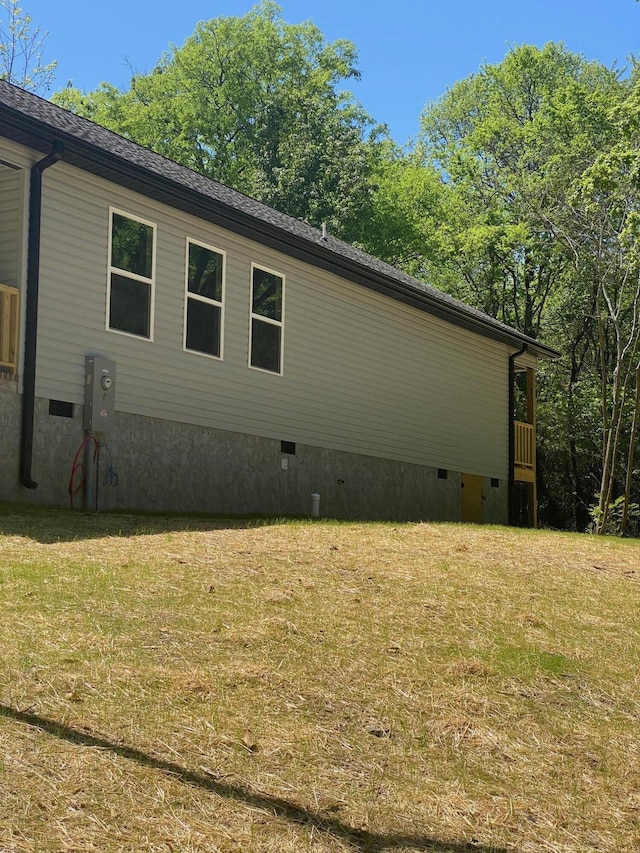 view of side of property with a yard and crawl space