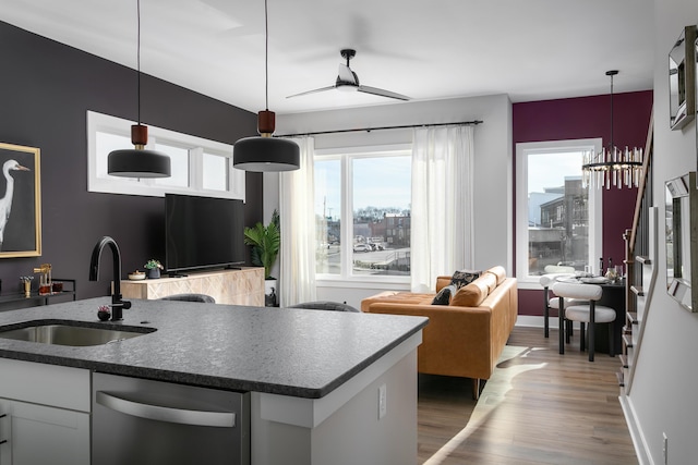 kitchen featuring decorative light fixtures, sink, white cabinetry, and stainless steel dishwasher