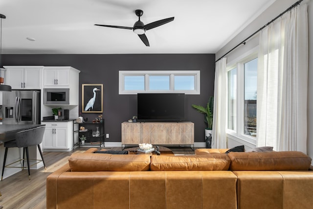 living room featuring light wood-type flooring and ceiling fan