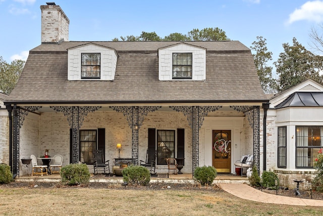 view of front of property featuring covered porch and a front yard