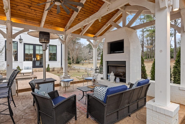 view of patio featuring ceiling fan and an outdoor living space with a fireplace