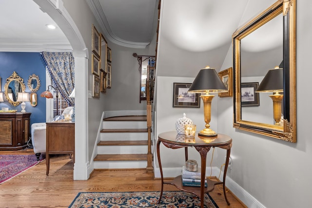 staircase featuring hardwood / wood-style flooring and ornamental molding