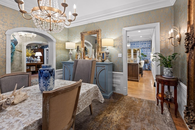 dining room featuring wood-type flooring, a chandelier, and ornamental molding