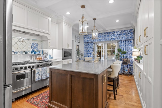 kitchen with white cabinets, stainless steel appliances, light hardwood / wood-style floors, a kitchen island with sink, and coffered ceiling