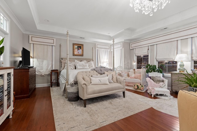 bedroom with beverage cooler, an inviting chandelier, dark hardwood / wood-style floors, ornamental molding, and a raised ceiling