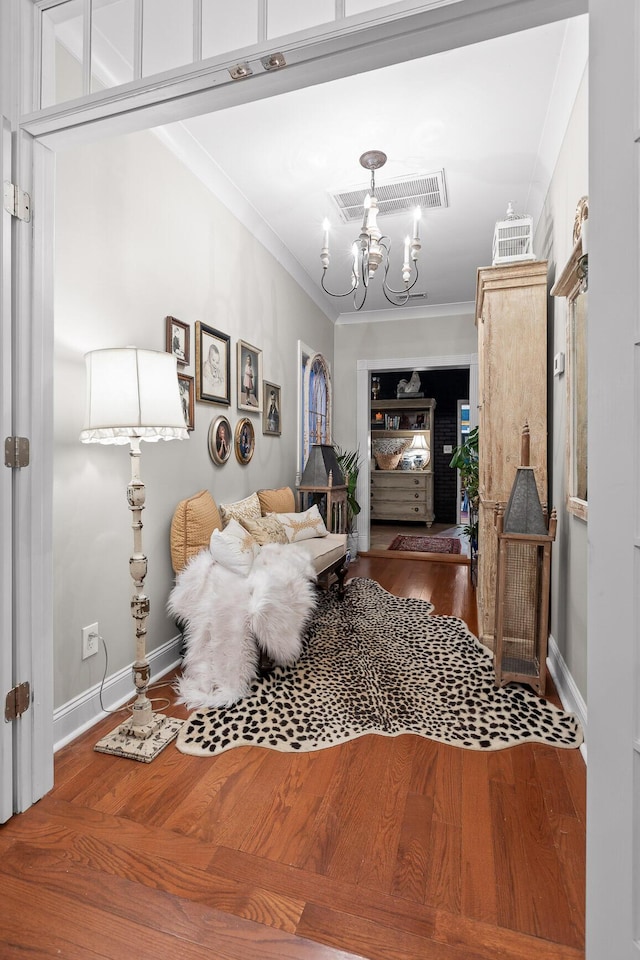 bedroom with hardwood / wood-style floors, a chandelier, and ornamental molding