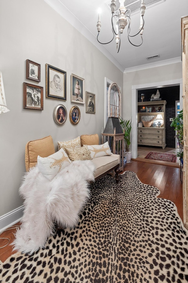 living room with hardwood / wood-style flooring, a chandelier, and ornamental molding