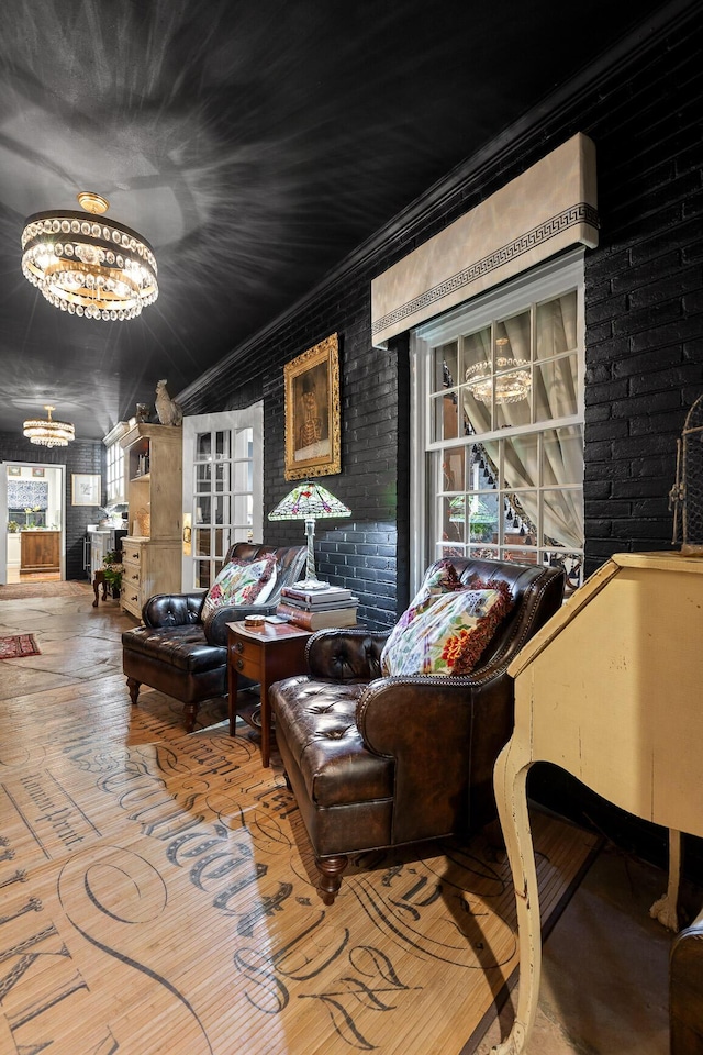 interior space featuring a chandelier, brick wall, and ornamental molding