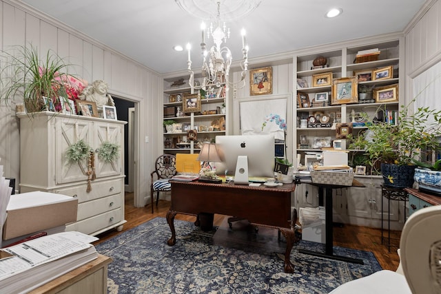 office featuring crown molding, hardwood / wood-style floors, an inviting chandelier, and built in features