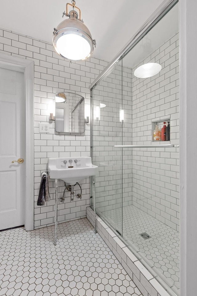 bathroom with a shower with shower door and tile patterned floors