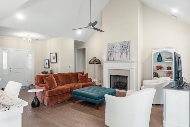 living room with high vaulted ceiling, dark hardwood / wood-style flooring, and ceiling fan with notable chandelier