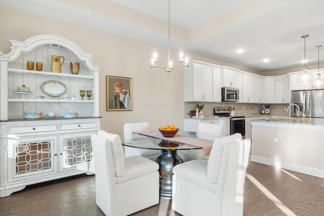 dining room featuring sink, a chandelier, and dark hardwood / wood-style flooring