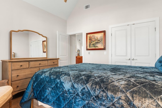 bedroom with hardwood / wood-style flooring, a closet, and high vaulted ceiling