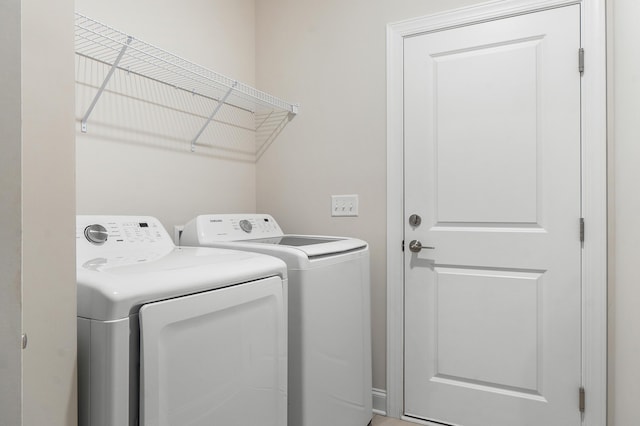 clothes washing area with washer and clothes dryer