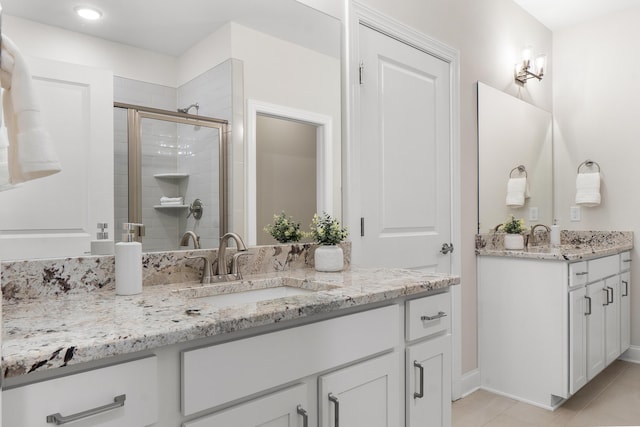 bathroom featuring vanity, a shower with door, and tile patterned flooring