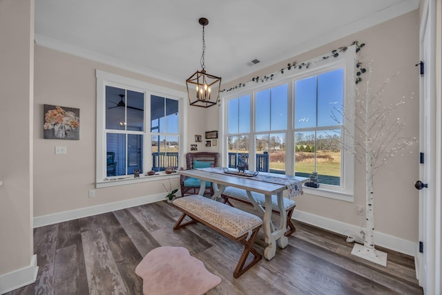 dining space with ornamental molding, hardwood / wood-style floors, and a notable chandelier