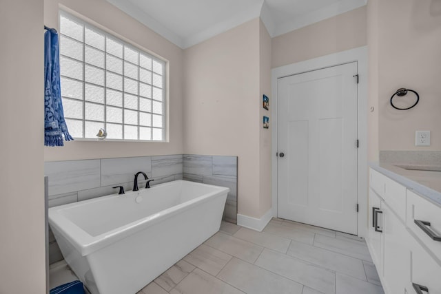 bathroom featuring tile walls, a tub to relax in, vanity, ornamental molding, and tile patterned floors