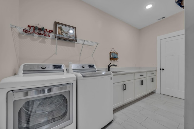 clothes washing area with cabinets, sink, and independent washer and dryer