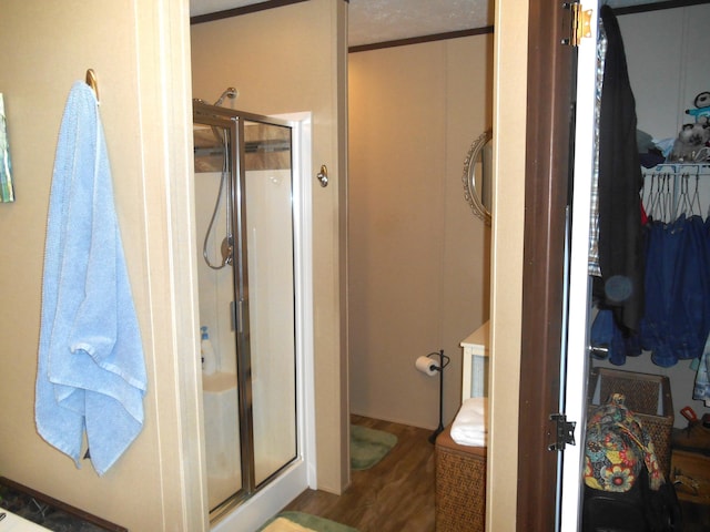 bathroom with hardwood / wood-style floors and a shower with door