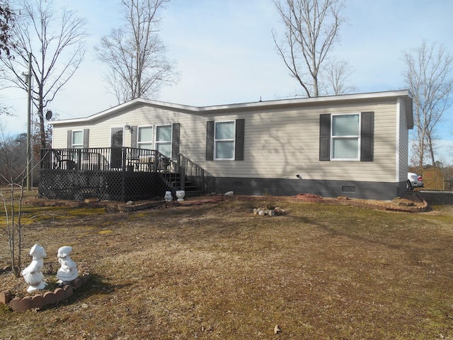 manufactured / mobile home with a wooden deck and a front yard