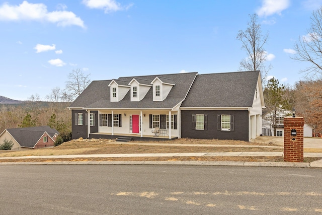 new england style home featuring a garage and a porch