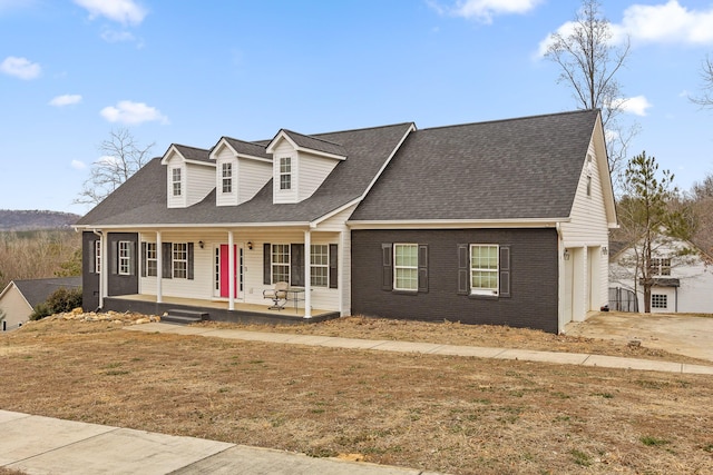 cape cod home featuring a porch and a front lawn