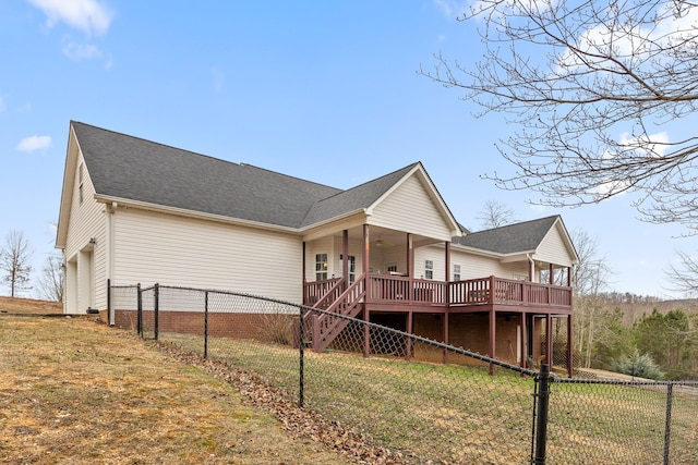 back of property with a wooden deck and a lawn