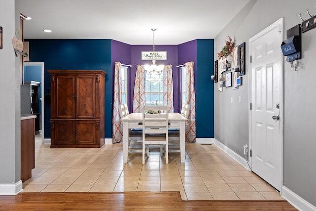 dining space with light tile patterned floors and a notable chandelier