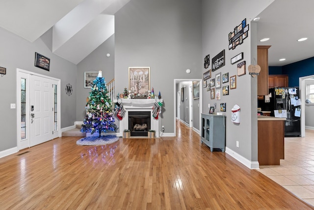 entryway featuring a towering ceiling and light hardwood / wood-style floors