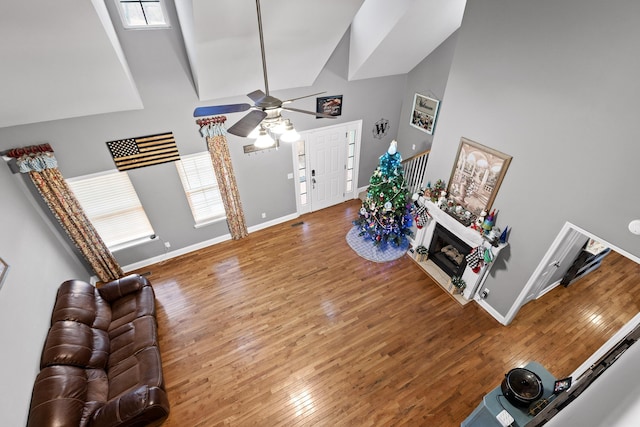 living room featuring hardwood / wood-style floors, high vaulted ceiling, and ceiling fan