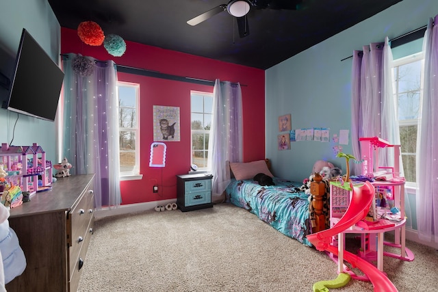 carpeted bedroom with ceiling fan and multiple windows