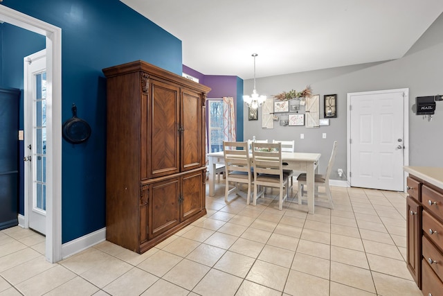 dining space with a wealth of natural light, light tile patterned floors, and a notable chandelier