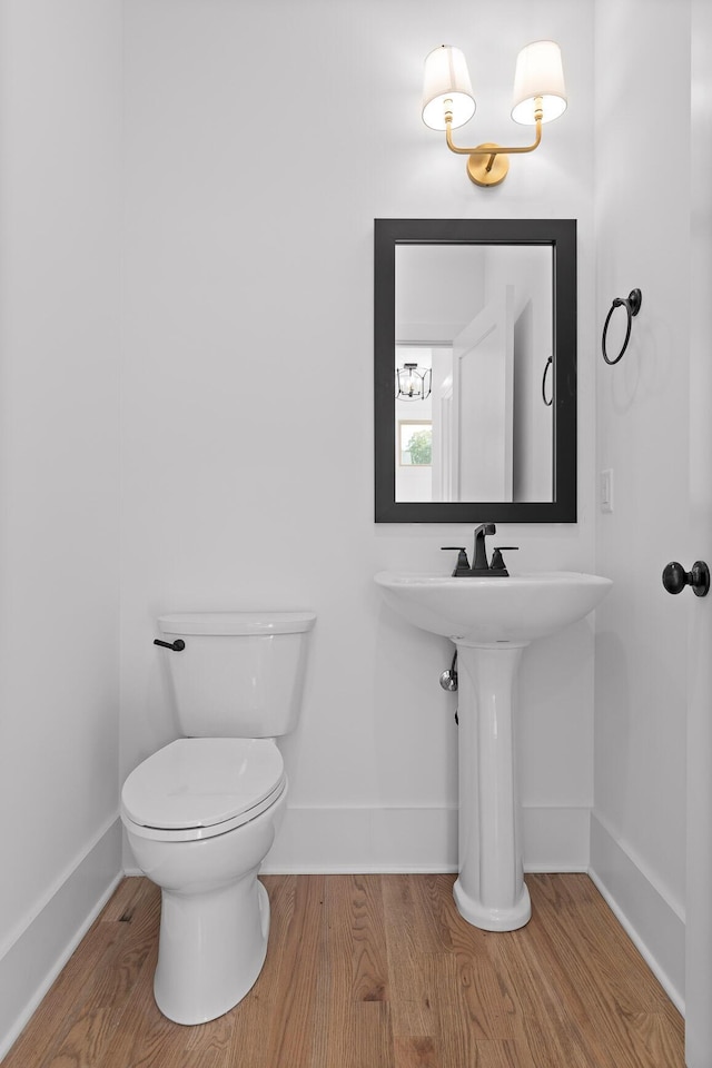 bathroom with wood-type flooring and toilet