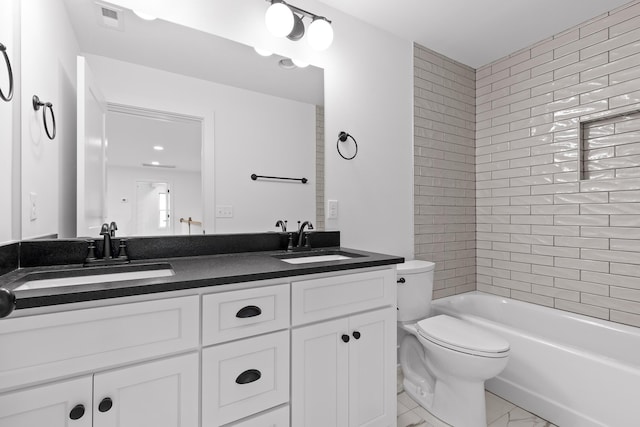 full bathroom featuring tiled shower / bath, vanity, and toilet