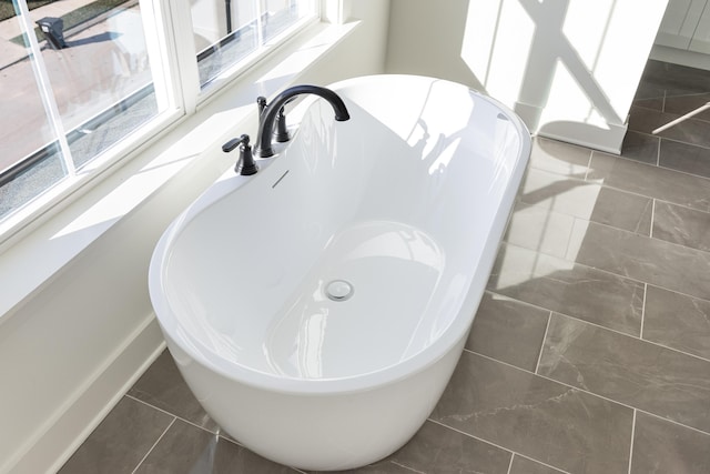 bathroom with a bathing tub and tile patterned floors