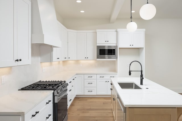 kitchen with premium range hood, white cabinetry, and stainless steel appliances