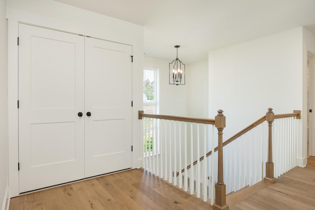 hall featuring plenty of natural light, an inviting chandelier, and light wood-type flooring