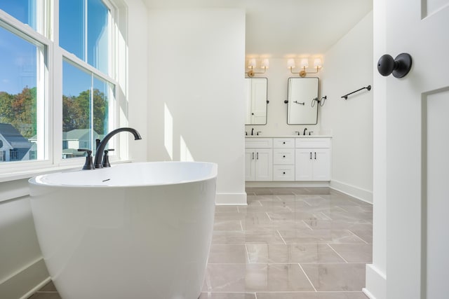 bathroom with vanity, a wealth of natural light, and a tub