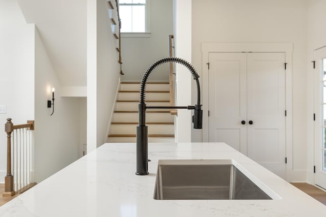 interior details featuring light stone countertops and sink