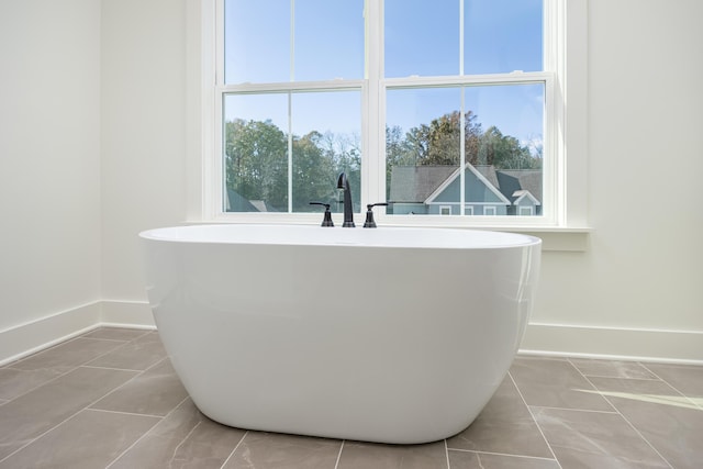 bathroom with tile patterned flooring and a tub