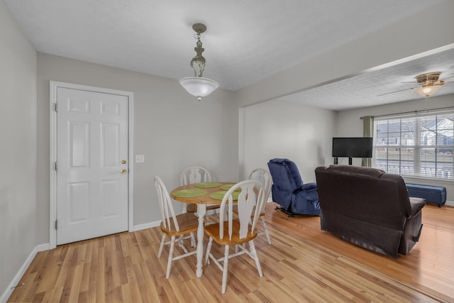 dining area with a textured ceiling, light hardwood / wood-style flooring, and ceiling fan