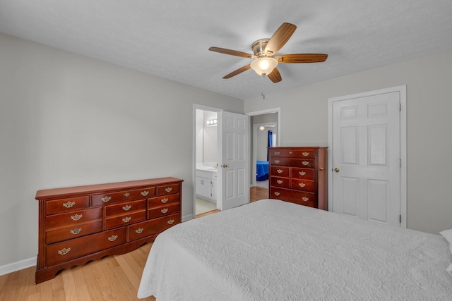 bedroom featuring ceiling fan, connected bathroom, light hardwood / wood-style flooring, and a textured ceiling