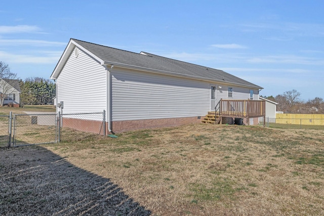 back of house featuring a deck and a lawn