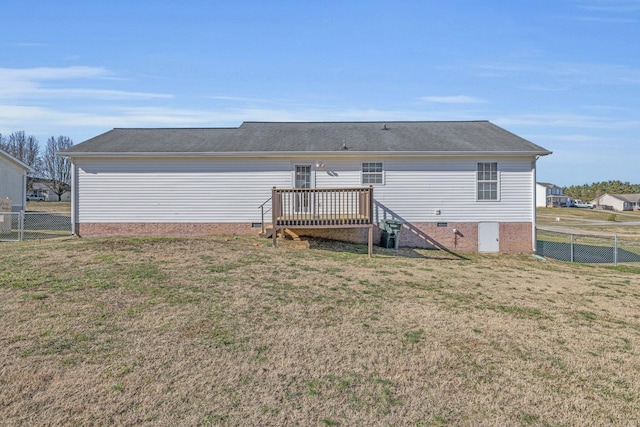 rear view of property featuring a wooden deck and a lawn