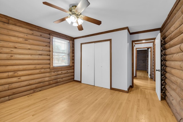 unfurnished bedroom with light hardwood / wood-style flooring, ornamental molding, a closet, and rustic walls